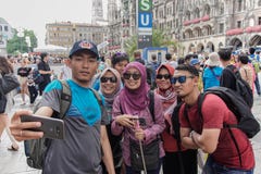 Asian Muslim tourist poses at pedestrian in Munich