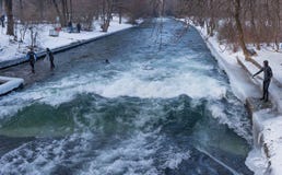 MUNICH †”JANUARI 28: En surfareridningöverkant av en våg på floden Isar royaltyfria bilder MUNICH †”JANUARI 28: En surfareridningöverkant av en våg på floden Isar royaltyfria bilder