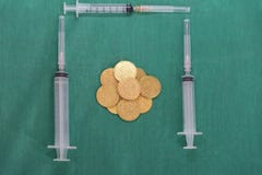 Muntstukken of geld met veelvoudige spuiten op chirurgie groene kleding cov stock fotografie Muntstukken of geld met veelvoudige spuiten op chirurgie groene kleding cov stock fotografie