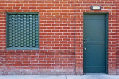 Mur de briques avec une porte verte en métal image libre de droits Mur de briques avec une porte verte en métal image libre de droits