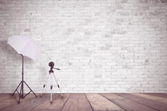 Mur de briques blanc dans un studio de photo Un parapluie pour l'illumination et un trépied pour un appareil-photo l'espace vide Photos stock Mur de briques blanc dans un studio de photo Un parapluie pour l'illumination et un trépied pour un appareil-photo l'espace vide Photos stock