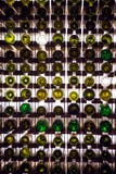 Mur des bouteilles de vin vides Les bouteilles de vin vides empilées- sur une une autre dans le modèle se sont allumées par la lu image libre de droits Mur des bouteilles de vin vides Les bouteilles de vin vides empilées- sur une une autre dans le modèle se sont allumées par la lu image libre de droits