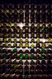 Mur des bouteilles de vin vides Les bouteilles de vin vides empilées- sur une une autre dans le modèle se sont allumées par la lu photos stock Mur des bouteilles de vin vides Les bouteilles de vin vides empilées- sur une une autre dans le modèle se sont allumées par la lu photos stock