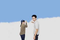 Mur heureux de peinture de couples de leur nouvelle maison photo stock Mur heureux de peinture de couples de leur nouvelle maison photo stock