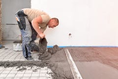 Murarz wyrównuje cementowego screed w niedawno budującym domu zdjęcia stock Murarz wyrównuje cementowego screed w niedawno budującym domu zdjęcia stock