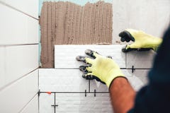 muratore che installa le piccole piastrelle di ceramica sulle pareti del bagno e che applica mortaio con la cazzuola fotografie stock muratore che installa le piccole piastrelle di ceramica sulle pareti del bagno e che applica mortaio con la cazzuola fotografie stock