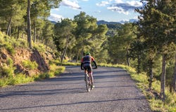Murcie, Espagne - 9 avril 2019 : Pro cyclistes de route supportant une montée difficile de montagne sur sa bicyclette fraîche images stock Murcie, Espagne - 9 avril 2019 : Pro cyclistes de route supportant une montée difficile de montagne sur sa bicyclette fraîche images stock