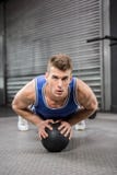 Muscular man doing pull up with medicine ball stock photography Muscular man doing pull up with medicine ball stock photography