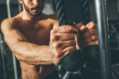 图象照片：解决在健身房的肌肉人做与三头肌绳索的锻炼