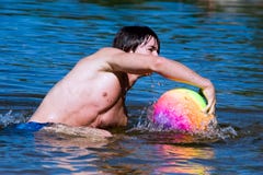 Muscular sport boy swimming in lake with ball Stock Image Muscular sport boy swimming in lake with ball Stock Image
