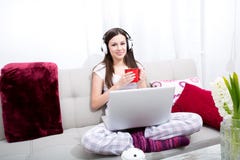 Musica d'ascolto a casa con il computer portatile Immagine Stock Musica d'ascolto a casa con il computer portatile Immagine Stock