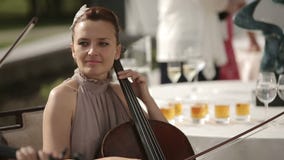 Musical quartet. Girl playing cello in a quartet of violinists. Medium shot. stock footage Musical quartet. Girl playing cello in a quartet of violinists. Medium shot. stock footage
