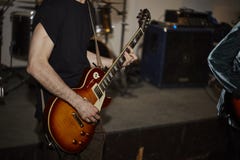 Musiker i svarta t-skjorta lekar på den elektriska gitarren royaltyfria bilder Musiker i svarta t-skjorta lekar på den elektriska gitarren royaltyfria bilder