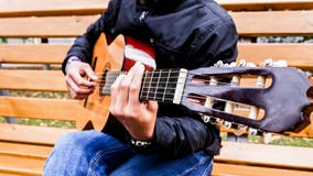 Musikern som spelar gitarren parkerar offentligt royaltyfri foto Musikern som spelar gitarren parkerar offentligt royaltyfri foto