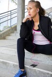 Musique de écoute de femme sportive réfléchie tout en se reposant sur des étapes photos libres de droits Musique de écoute de femme sportive réfléchie tout en se reposant sur des étapes photos libres de droits