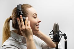 Musique, industrie du spectacle, les gens et concept de voix - chanteur avec les écouteurs et le microphone chantant une chanson photos stock Musique, industrie du spectacle, les gens et concept de voix - chanteur avec les écouteurs et le microphone chantant une chanson photos stock