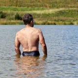 Muskulöser Mann von mittlerem Alter badet im kleinen Vorstadtsee im Sommer R?ckseitige Ansicht stockfotografie Muskulöser Mann von mittlerem Alter badet im kleinen Vorstadtsee im Sommer R?ckseitige Ansicht stockfotografie