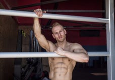 Muskulöst shirtless anseende för ung man i idrottshall royaltyfri foto Muskulöst shirtless anseende för ung man i idrottshall royaltyfri foto
