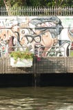 Muslim woman walks by a graffiti by a canal in Bangkok, Thailand stock photography Muslim woman walks by a graffiti by a canal in Bangkok, Thailand stock photography