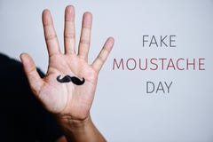 Mustaschen i en hand och text fejkar mustaschdag royaltyfria foton Mustaschen i en hand och text fejkar mustaschdag royaltyfria foton