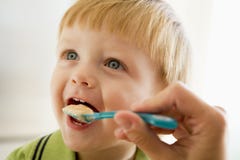 Mutter, die junge Jungensäuglingsnahrung speist lizenzfreies stockbild Mutter, die junge Jungensäuglingsnahrung speist lizenzfreies stockbild