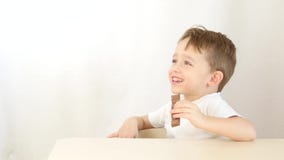 Mutter gab dem Kind Schokolade, er isst sie mit dem Vergnügen und oben saß am Tabellenabschluß stock video Mutter gab dem Kind Schokolade, er isst sie mit dem Vergnügen und oben saß am Tabellenabschluß stock video