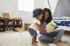 Mutter-und Baby-Tochter-Lesebuch im Spielzimmer zusammen lizenzfreie stockbilder Mutter-und Baby-Tochter-Lesebuch im Spielzimmer zusammen lizenzfreie stockbilder