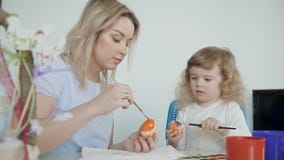 Mutter und ihre kleine Tochter, die Ostereier malen Mutter und ihre kleine Tochter, die Ostereier malen