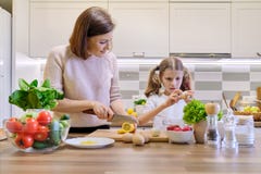 Mutter und Kind, die zusammen zu Hause in der K?che kochen Gesunde Ern?hrung, Mutter unterrichtet Tochter zu kochen, Elternteilki lizenzfreies stockbild Mutter und Kind, die zusammen zu Hause in der K?che kochen Gesunde Ern?hrung, Mutter unterrichtet Tochter zu kochen, Elternteilki lizenzfreies stockbild