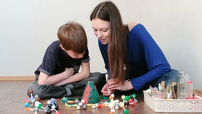 Mutter und Sohn machen Erfahrung mit Plasticinevulkan zu Hause Chemische Reaktion mit Abgasemission Mutter gießt Pulver von stock footage Mutter und Sohn machen Erfahrung mit Plasticinevulkan zu Hause Chemische Reaktion mit Abgasemission Mutter gießt Pulver von stock footage