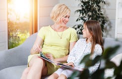 Mutter und Tochter, die auf dem Sofa sitzen stockbilder Mutter und Tochter, die auf dem Sofa sitzen stockbilder