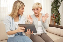 Mutter und Tochter sind beim Betrachten einer Tablette überrascht und überrascht stockbild Mutter und Tochter sind beim Betrachten einer Tablette überrascht und überrascht stockbild