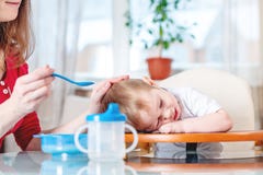 Mutter, welche die Babyholdinghand mit einem Löffel des Breis einzieht Gefühle eines Kindes beim Essen der gesunden Nahrung lizenzfreie stockbilder Mutter, welche die Babyholdinghand mit einem Löffel des Breis einzieht Gefühle eines Kindes beim Essen der gesunden Nahrung lizenzfreie stockbilder