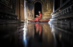 Myanmar - December 5, 2016: A Myanmar Little Novice Monk reading buddhism book in front of the door of temple, Shan District royalty free stock photos Myanmar - December 5, 2016: A Myanmar Little Novice Monk reading buddhism book in front of the door of temple, Shan District royalty free stock photos