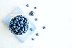 Myrtilles fraîches dans la cuvette avec une cuillère en bois sur une table blanche Vue supérieure, flatlay images stock Myrtilles fraîches dans la cuvette avec une cuillère en bois sur une table blanche Vue supérieure, flatlay images stock