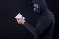 Mystery man holding and looking at white mask royalty free stock image Mystery man holding and looking at white mask royalty free stock image