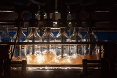 A máquina de enchimento automática derrama o líquido nas garrafas de vidro Produção da fabricação de cerveja Fundo industrial fotos de stock A máquina de enchimento automática derrama o líquido nas garrafas de vidro Produção da fabricação de cerveja Fundo industrial fotos de stock
