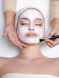 Máscara apllying del Cosmetician en la cara de la mujer imagenes de archivo Máscara apllying del Cosmetician en la cara de la mujer imagenes de archivo