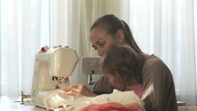 Mãe atrativa nova que trabalha na máquina de costura com sua filha bonito pequena vídeos de arquivo Mãe atrativa nova que trabalha na máquina de costura com sua filha bonito pequena vídeos de arquivo