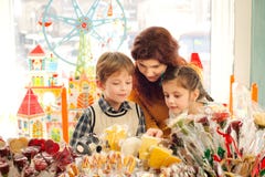 Mãe com as crianças felizes na loja de doces imagem de stock Mãe com as crianças felizes na loja de doces imagem de stock