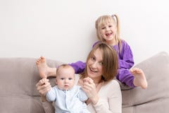 Mãe com o filho e a filha que têm o divertimento no sofá Sorriso e povos alegres Conceito de família feliz foto de stock Mãe com o filho e a filha que têm o divertimento no sofá Sorriso e povos alegres Conceito de família feliz foto de stock