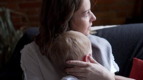 Mãe com o filho que relaxa na poltrona Mãe com o filho que relaxa na poltrona