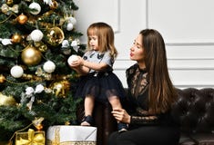 Mãe com sua filha da criança que comemora perto da árvore de Natal imagens de stock royalty free Mãe com sua filha da criança que comemora perto da árvore de Natal imagens de stock royalty free