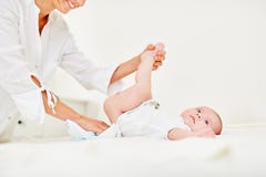 A mãe de inquietação muda tecidos do bebê Imagens de Stock A mãe de inquietação muda tecidos do bebê Imagens de Stock