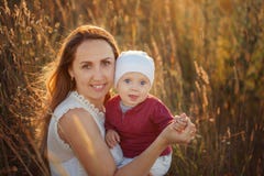 Mãe do retrato com a criança nos braços do dia de verão A família está sorrindo imagem de stock Mãe do retrato com a criança nos braços do dia de verão A família está sorrindo imagem de stock