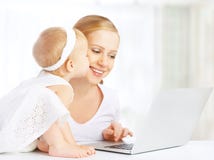 Mãe e bebê em casa que usam o laptop imagem de stock Mãe e bebê em casa que usam o laptop imagem de stock