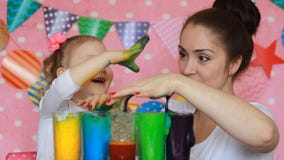 A mãe e a criança estão fazendo uma experiência com espuma colorida Aniversário celebration Mãos sujas na pintura Cor do estudo p filme A mãe e a criança estão fazendo uma experiência com espuma colorida Aniversário celebration Mãos sujas na pintura Cor do estudo p filme