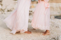 A mãe e a filha estão estando em uma rocha em vestidos cor-de-rosa fotos de stock royalty free A mãe e a filha estão estando em uma rocha em vestidos cor-de-rosa fotos de stock royalty free