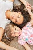 Mãe e filha pequena que encontram-se junto foto de stock royalty free Mãe e filha pequena que encontram-se junto foto de stock royalty free
