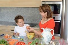 Mãe e filho que preparam o almoço usando ovos e sorriso fotografia de stock royalty free Mãe e filho que preparam o almoço usando ovos e sorriso fotografia de stock royalty free